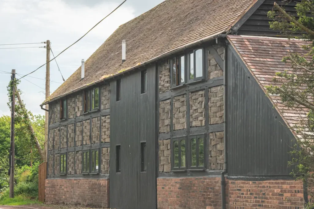 a building with a brick wall and a black door