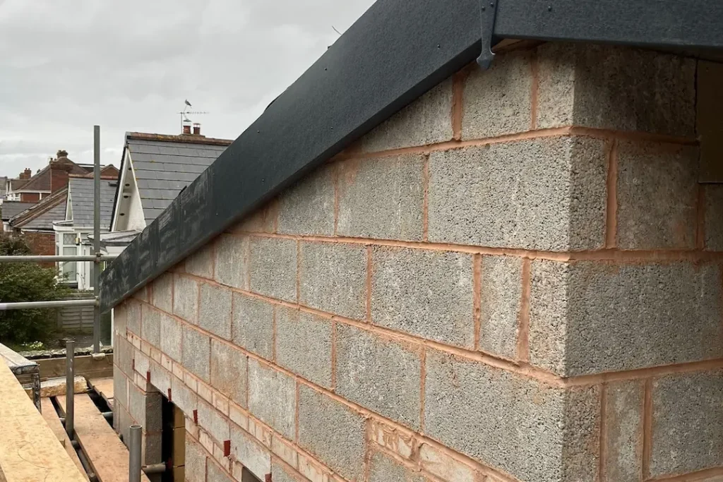 a brick wall with a black roof